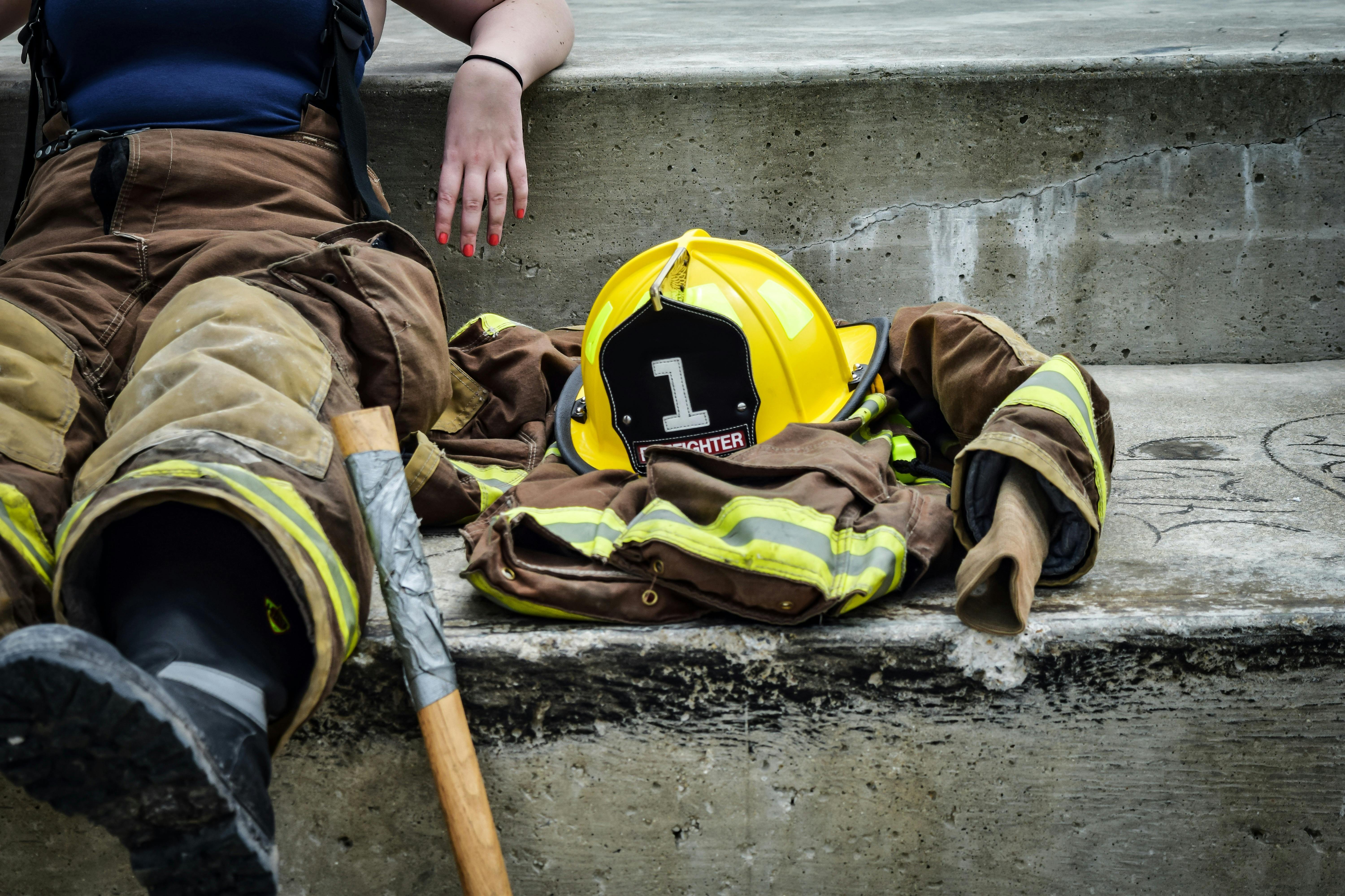 the true costs of outdated fire equipment fire fighter with coat and helmet next to them